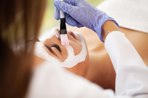 Beautiful woman with facial mask at beauty salon