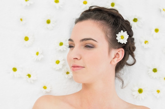 Beautiful woman with flowers in beauty salon