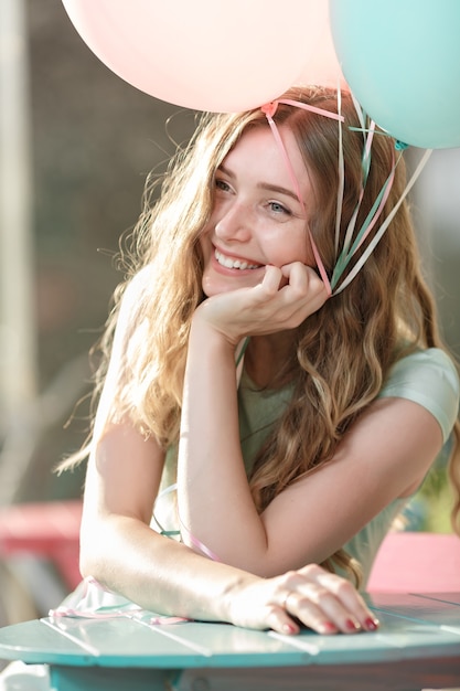 Beautiful woman with flying multicolored balloons. happiness and dreams concept.