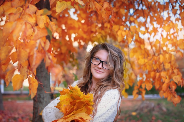 Beautiful woman with glasses in the park in autumn