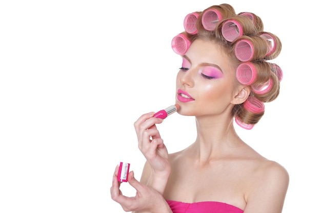 Beautiful woman with hair curlers with lipstick