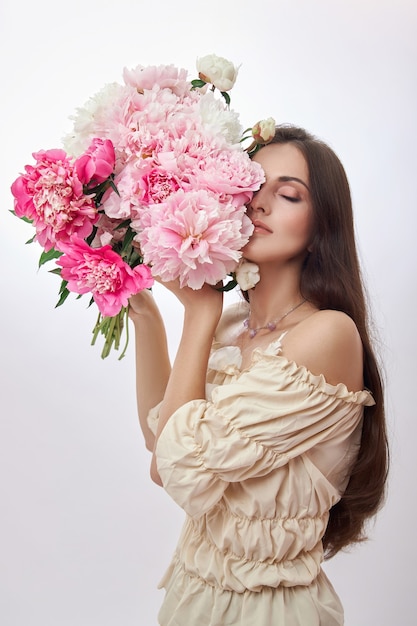 Beautiful woman with lots of pink flowers in her hands.