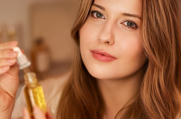 Beautiful woman with organic oil serum bottle evening beauty and skincare routine