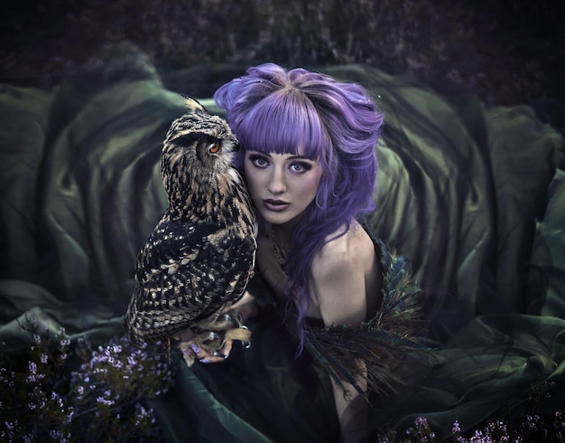 Beautiful woman with owl in the nature