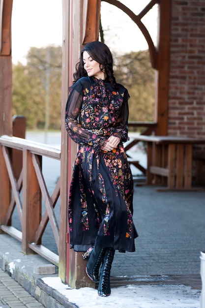 Photo beautiful woman with smile in dress near wooden handrail