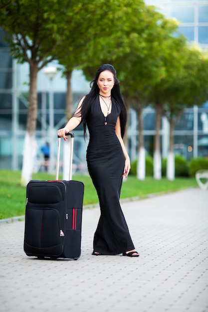 Beautiful woman with a suitcase near the airport.