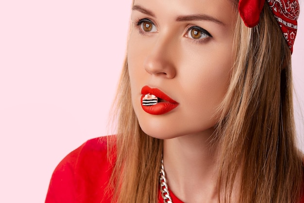 Beautiful woman with tiny cake on her mouth healthy unhealthy eating diet concept