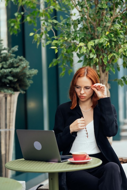 Beautiful woman working on laptop at outdoors cafe