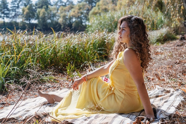 Beautiful woman in yellow dress on a picnic