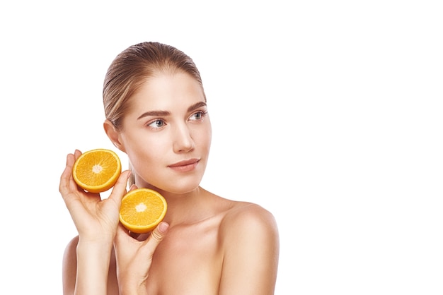 Beautiful womans face with orange close up studio photo on white background. Light hair, grey eyes