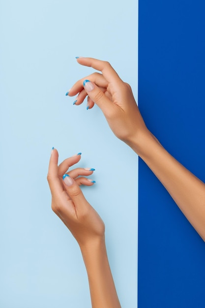 Beautiful womans hands trendy nail design on blue background