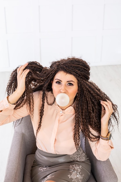 beautiful women blowing bubble from chewing gum and looking into the camera. High quality photo