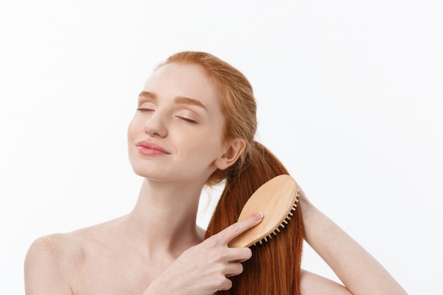 Photo beautiful women combing hair with wooden comb isolate over white background.