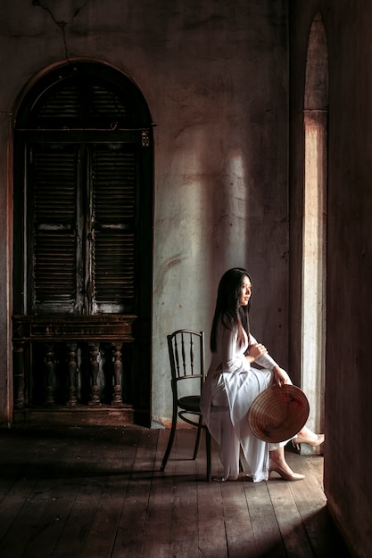 Beautiful women in traditional Vietnam national costumes Was sitting at the door of the house