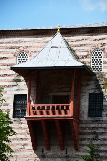 Beautiful wooden balcony with a conical roof An old stone building with a balcony