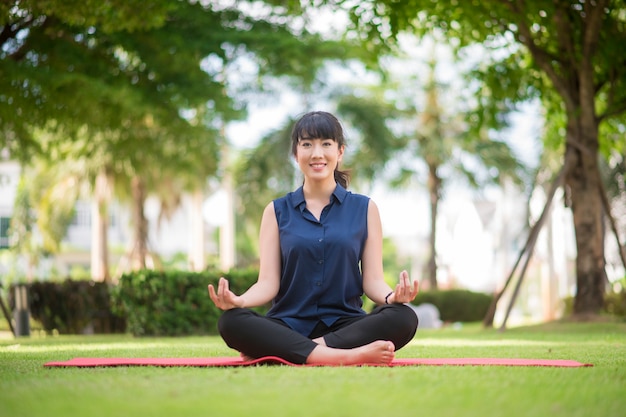 Beautiful yoga woman on green park