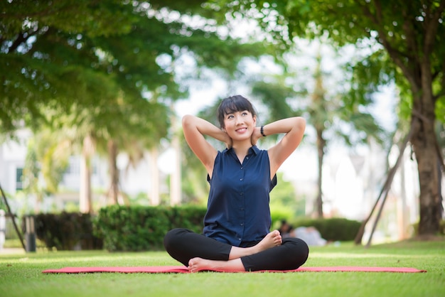 Beautiful yoga woman on green park