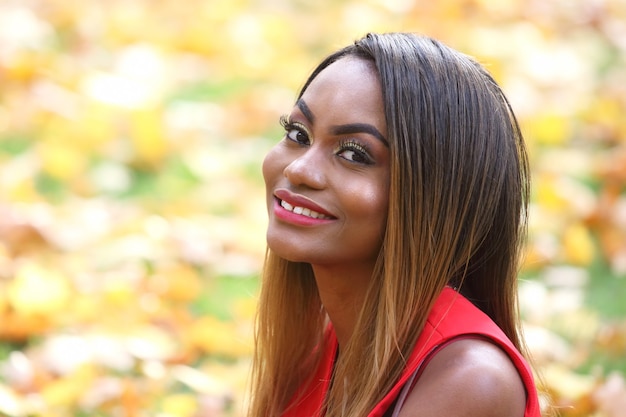 Beautiful young African woman autumn leaves