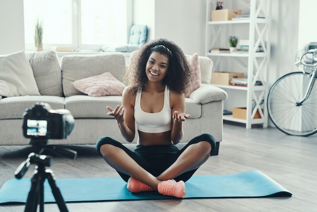 Beautiful young African woman working out and smiling while making social media video