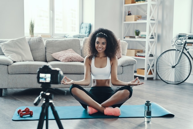 Beautiful young African woman working out and smiling while making social media video