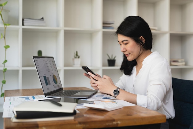 Beautiful young asian business woman using phone in office