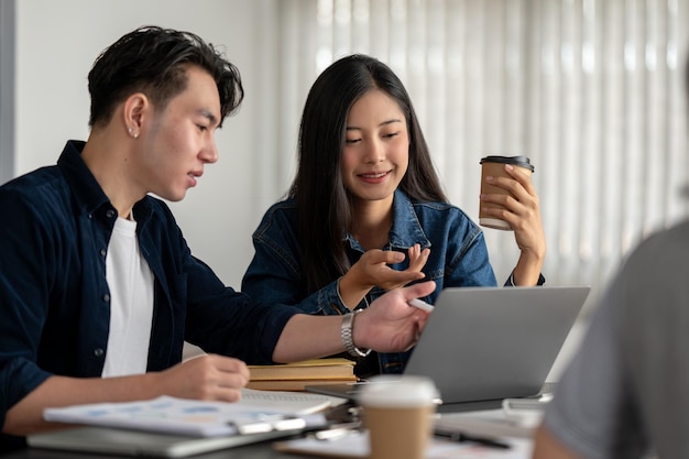 A beautiful young Asian businesswoman is listening ideas from her colleague planning a new project