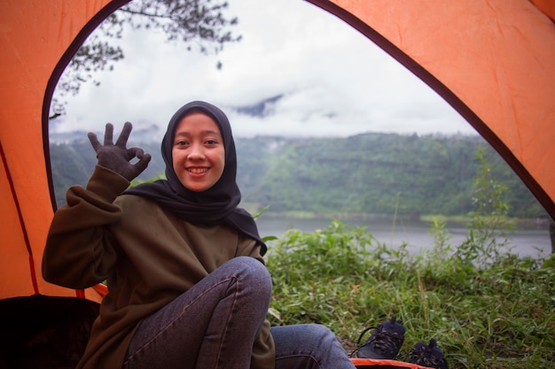 beautiful young asian muslim woman enjoy camping in tent