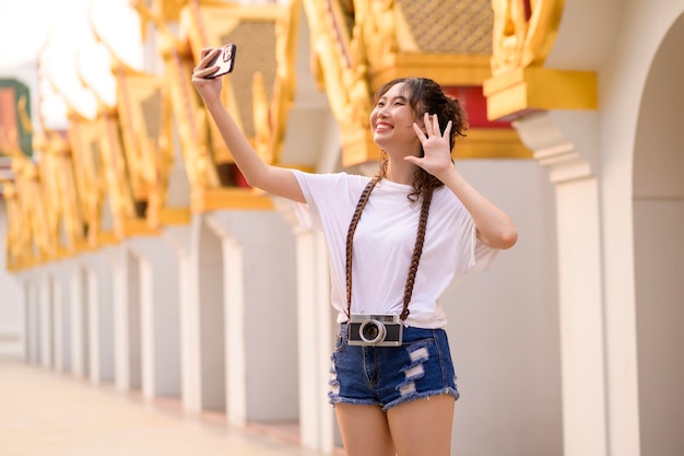 Beautiful young Asian tourist woman on vacation sightseeing and exploring Bangkok city Thailand