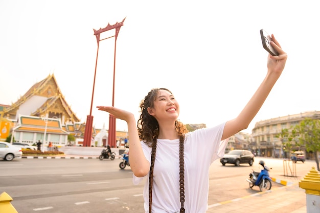 Beautiful young Asian tourist woman on vacation sightseeing and exploring Bangkok city