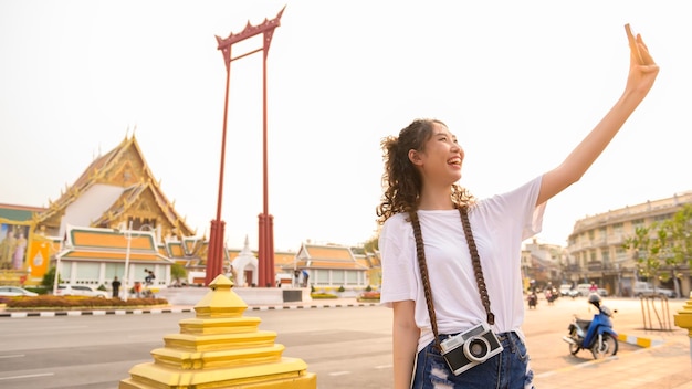 Beautiful young Asian tourist woman on vacation sightseeing and exploring Bangkok city