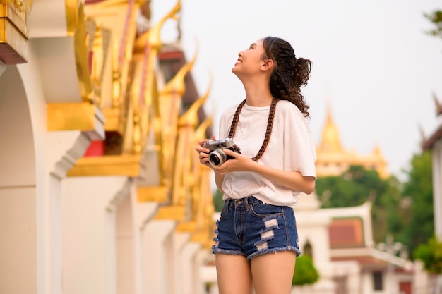 Beautiful young Asian tourist woman on vacation sightseeing and exploring Bangkok