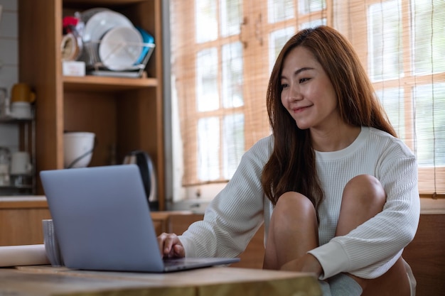 A beautiful young asian woman freelancer using laptop computer for working online at home