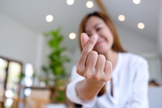 A beautiful young asian woman making and showing mini heart hand sign