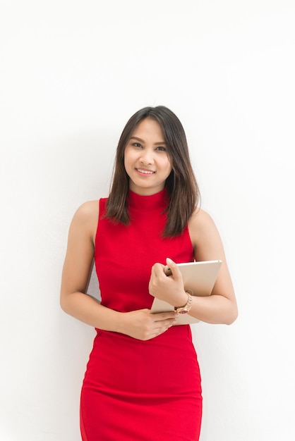 Beautiful young Asian woman in red dressshe has a tablet in handofficer work concept