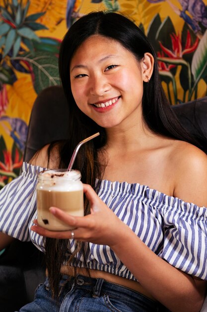 Beautiful young asian woman smiles having a coffee