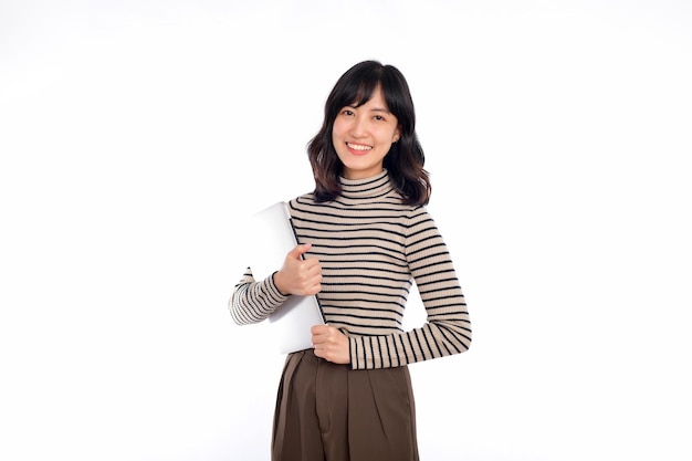 Beautiful young Asian woman on sweater clothing holding laptop pc computer and looking at camera with smile face isolated on white background