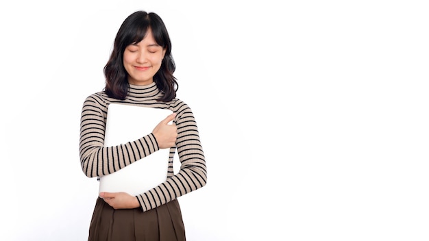 Beautiful young Asian woman on sweater clothing holding laptop pc computer and looking at camera with smile face isolated on white background