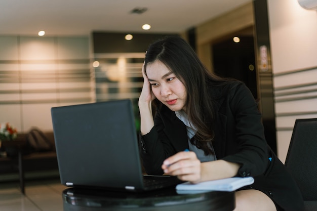 Beautiful young Asian woman using her laptop