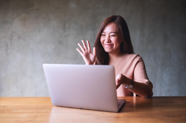 A beautiful young asian woman using laptop computer for video call and working online at home