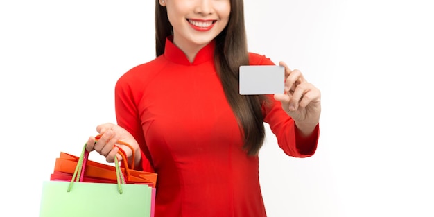 Beautiful young asian woman wear red vietnamese traditional dress with hand holding credit card to showing trust and confidence for making payment