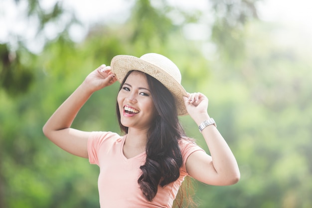 Beautiful young asian woman wearing round hat on a park