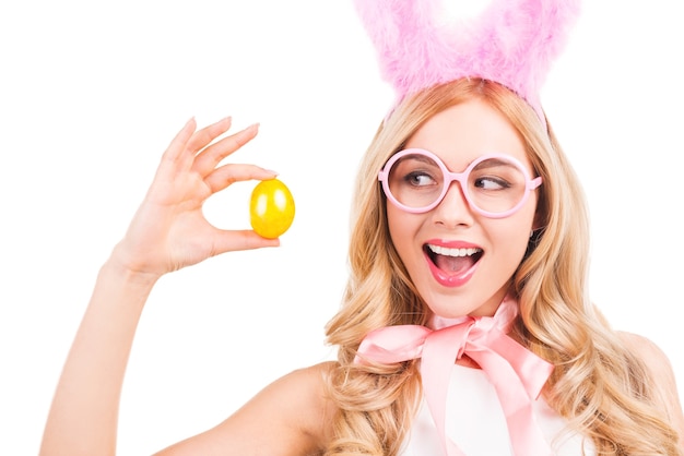 Beautiful young blond hair woman with rabbit ears holding easter egg