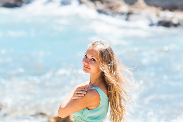 Beautiful young blond woman outdoors portrait near the sea or ocean