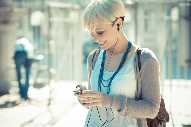 beautiful young blonde short hair hipster woman listening music earphones