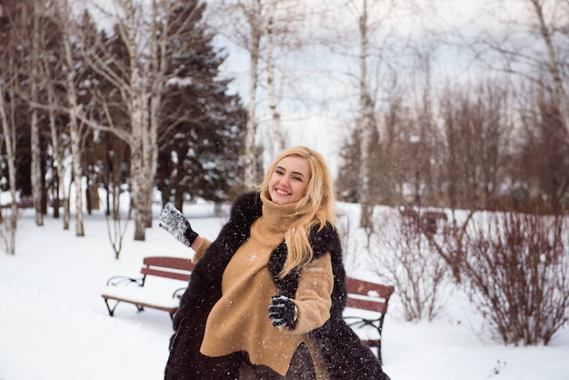 Beautiful young blonde woman in winter park