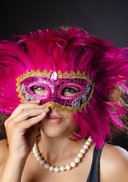 Beautiful young Brazilian woman with brown hair wearing a Venetian mask