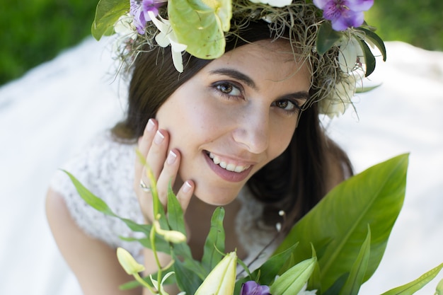 Beautiful young bride in a wreath with a bouquet in hand