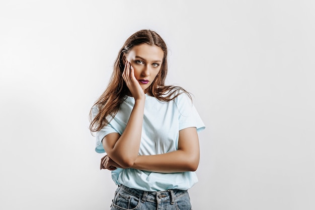 Beautiful young brunette girl with green eyes with long hair with fashion makeup with purple lips