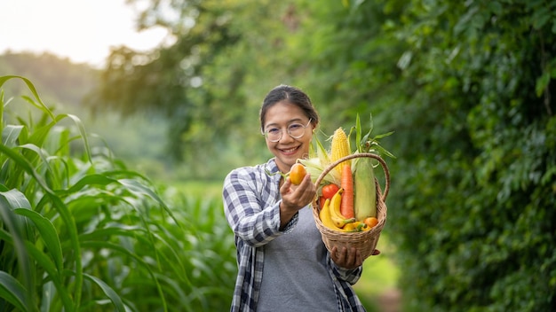 Beautiful young brunette Portrait Famer Woman hand holding Vegetables in the bamboo basket on green