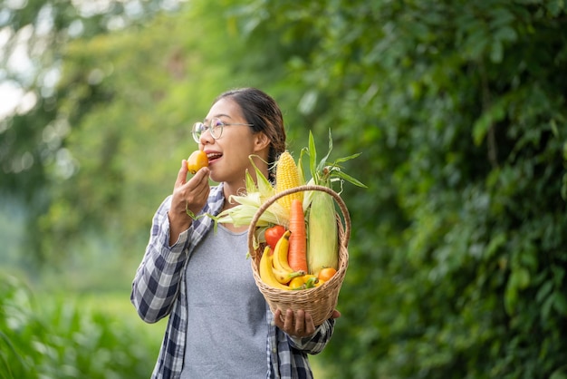 Beautiful young brunette Portrait Famer Woman hand holding Vegetables in the bamboo basket on green